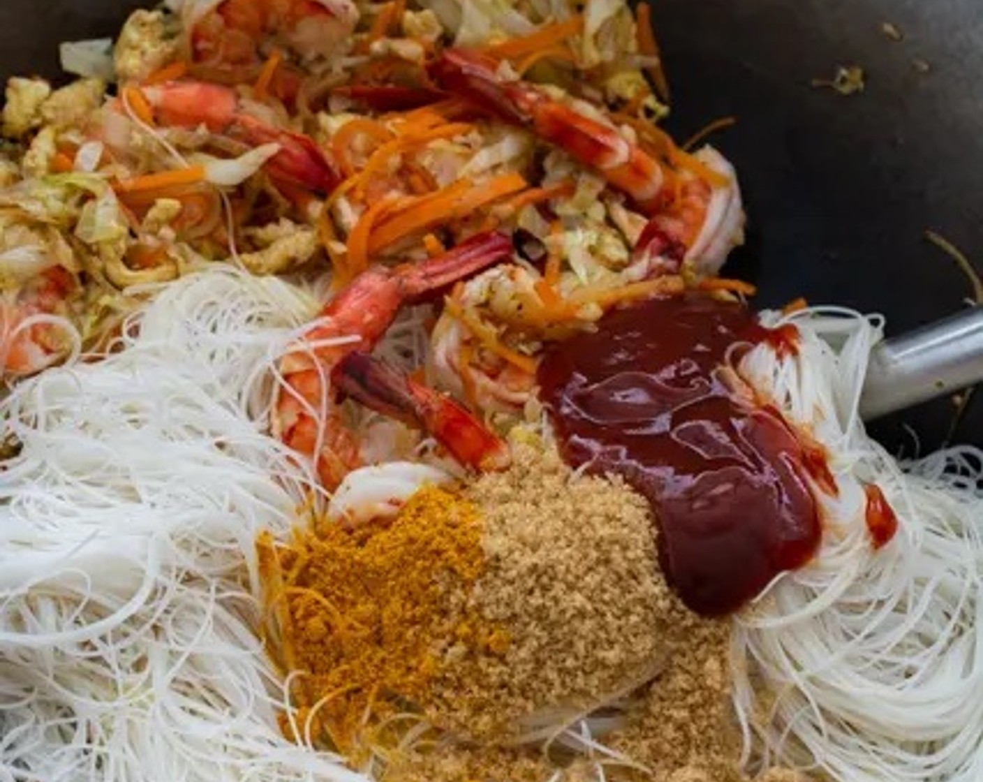 step 9 Add the vermicelli noodles to the wok, along with the sauce and curry powder mixture. Stir to combine all ingredients, ensuring that all of the noodles are evenly coated in the sauce and seasoning.