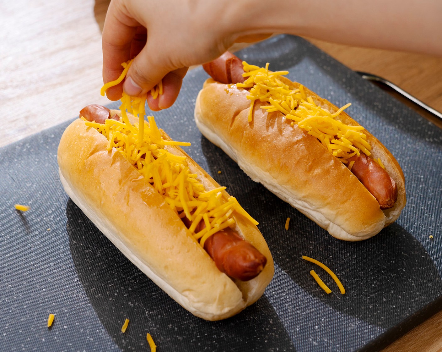 step 4 Place the hotdog into the Hot Dog Buns (4), top with Shredded Cheddar Cheese (1/2 cup), and back into the Air-fryer cook for another 2 minutes.