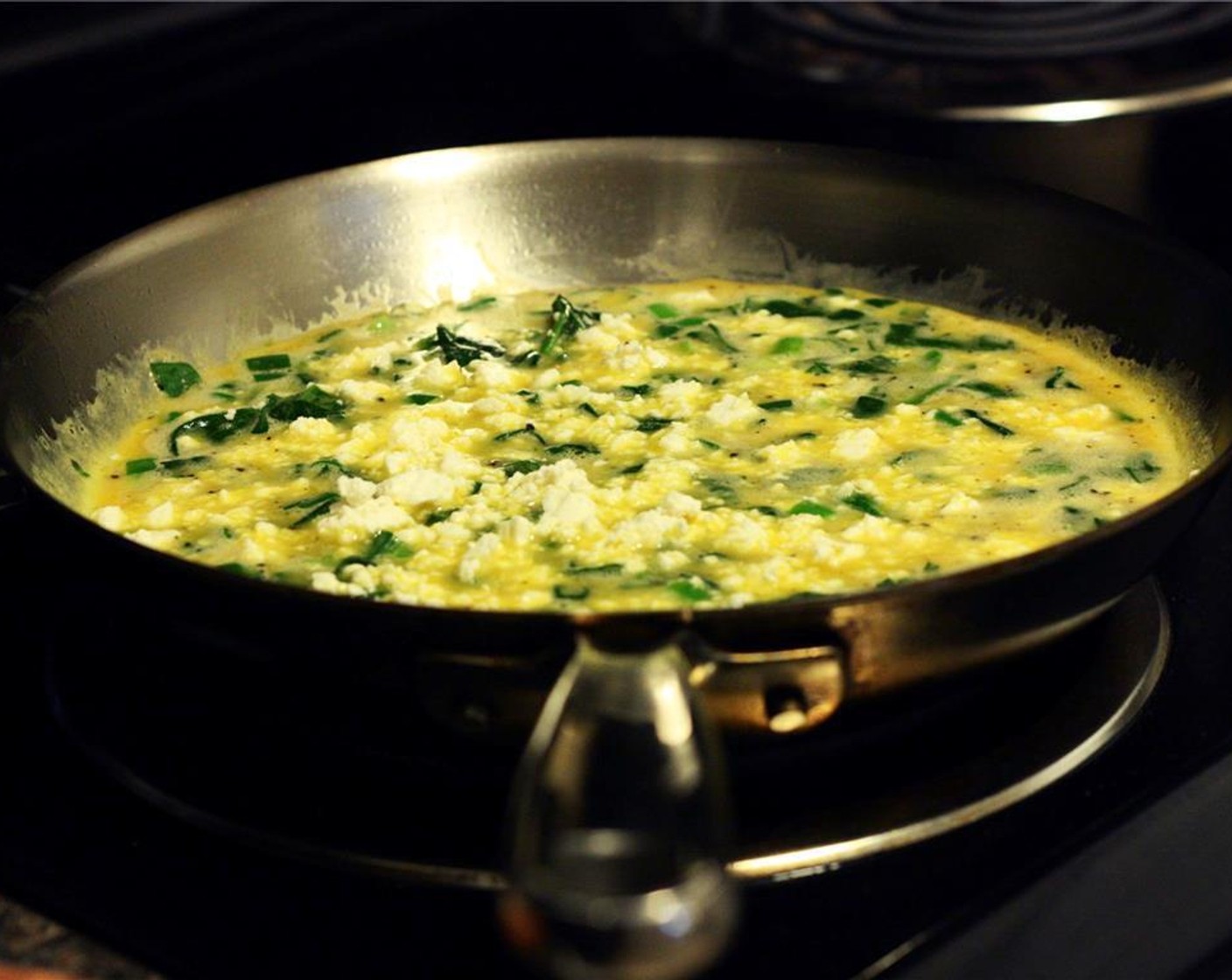 step 6 Pour in egg mixture and quickly stir so the spinach and scallions are evenly distributed. From this point on, do not stir the mixture. Sprinkle the Feta Cheese evenly over the top of the eggs.