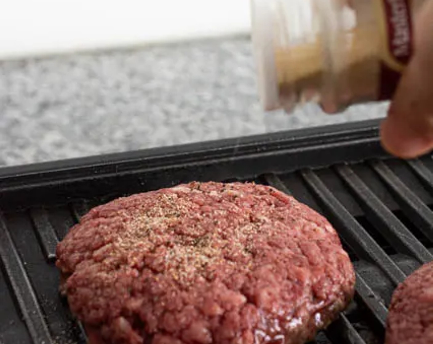 step 3 Season the Ground Beef (1 lb) generously with Salt (to taste), Ground Black Pepper (to taste), and McCormick® Garlic Powder (to taste). Gently place the burger patties on a grill or cast-iron skillet. Allow the burger to sear for about 2 minutes before flipping them over.