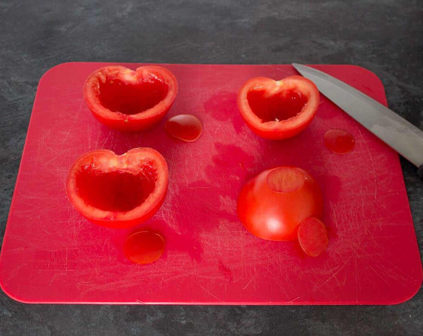 step 2 Halve and deseed the Beefsteak Tomatoes (2). Then slice a thin piece off the bottom so they don’t roll about on the tray.