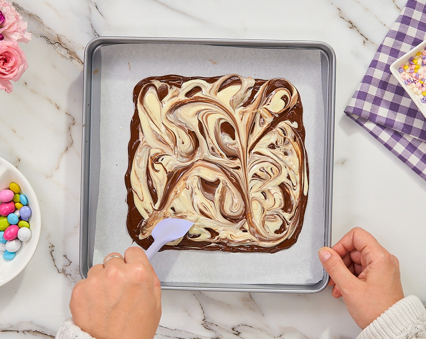 step 4 Spoon large spoonfuls of the white chocolate on top and, working quickly, use a spatula or the back of a spoon to swirl the chocolates in a decorative pattern.