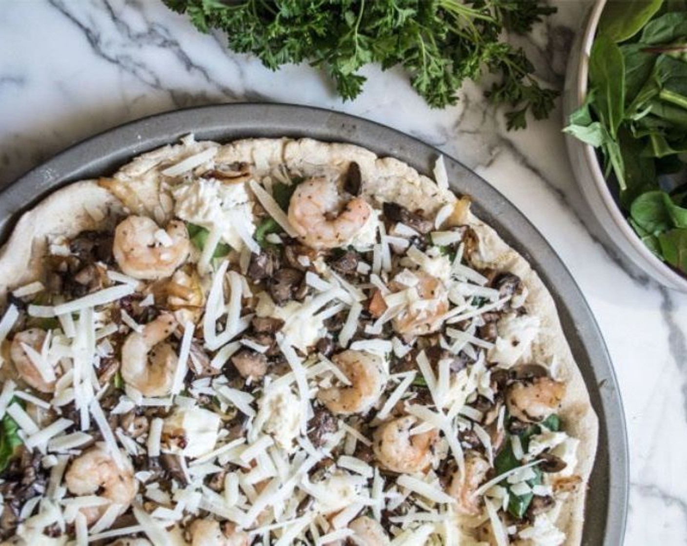 step 8 Top prebaked gluten-free pizza dough with sauce, followed by Fresh Baby Spinach (1 handful), Mozzarella Cheese (1 cup), caramelized onions, mushrooms, and shrimp. Finally, add Shaved Parmesan Cheese (1/3 cup).