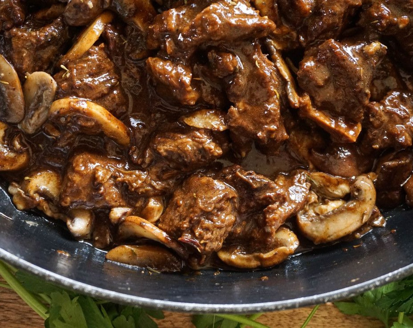 step 7 Just as the beef is tender and nearly done, melt the Butter (2 Tbsp) in a large saute pan. Add the Cremini Mushrooms (4 1/2 cups), Dried Thyme (1 tsp), Salt (to taste), and Ground Black Pepper (to taste). Cook until tender and caramelized, about 5 minutes. Add to the beef.