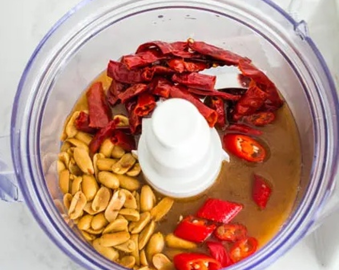 step 5 Pour the tamarind juice into a food processor, along with the dried chili pepper, Red Chili Peppers (2) and Chopped Roasted Peanuts (4 Tbsp). Blend all the ingredients until it forms a thick sambal paste.