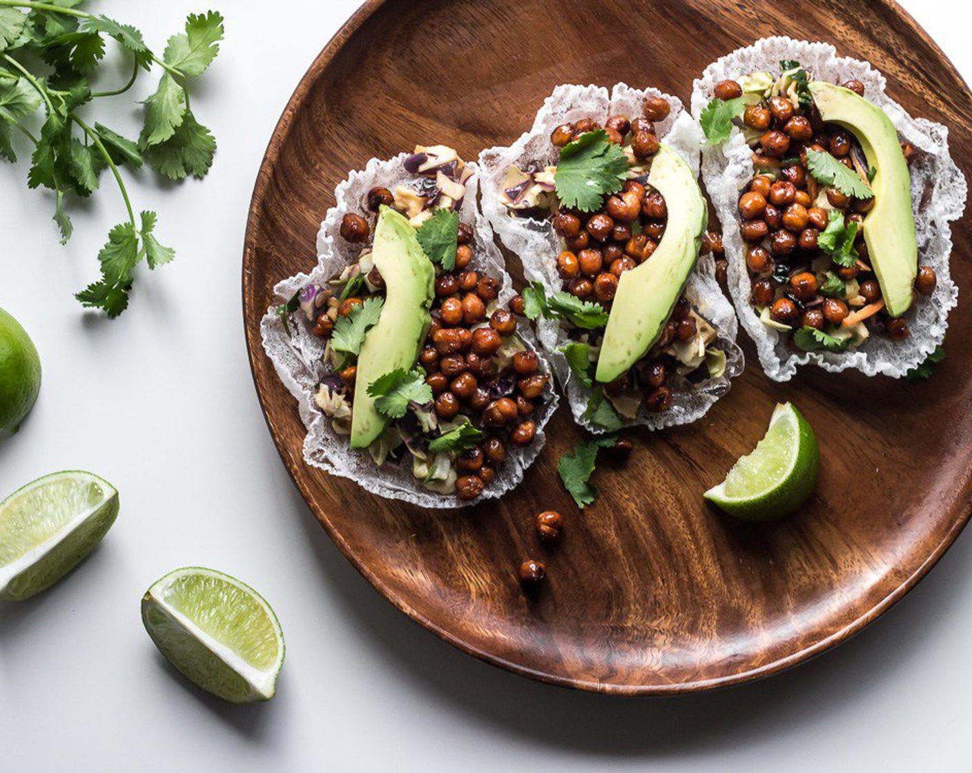 step 10 Once the chickpeas are done roasting, assemble the tacos by filling each rice paper taco shell with some of the Asian chopped salad, a scoop of chickpeas, Avocado (1), Fresh Cilantro (1/2 cup), and serve with a Lime Wedge. Serve and enjoy!