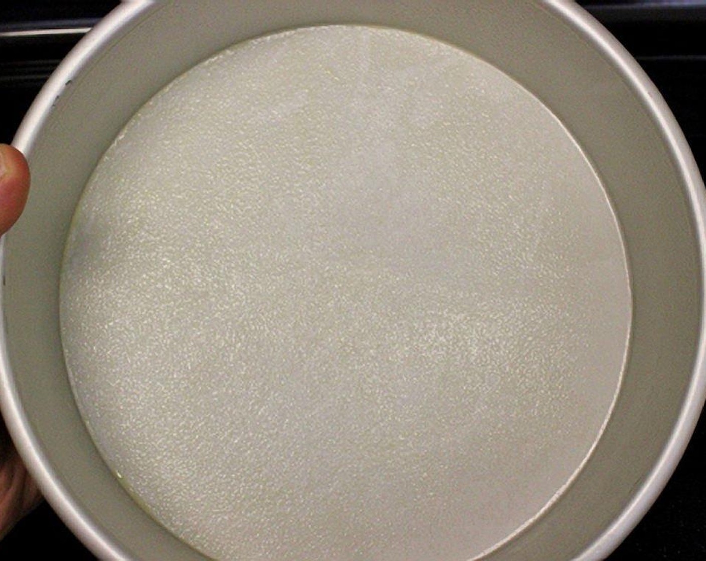 step 2 Grease and flour a 10-inch round cake pan. Line the bottom of the pan with parchment paper. Spray the top of the parchment paper with cooking spray or use butter/oil and flour to grease the pan.