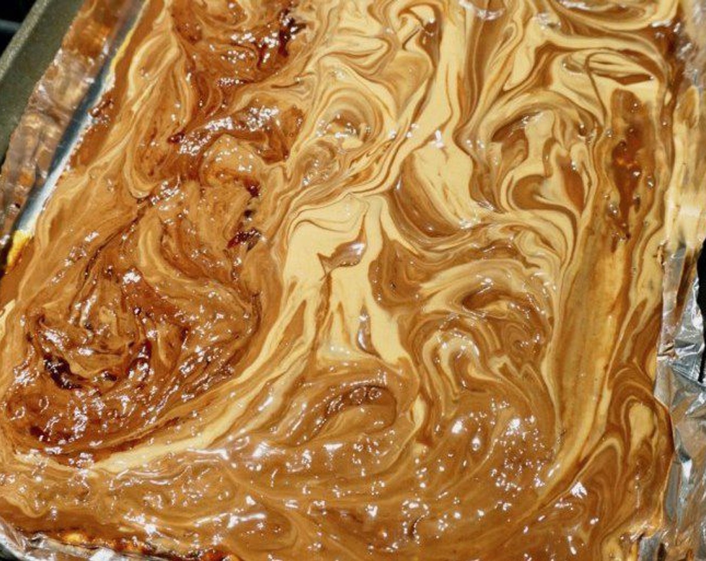 step 6 Meanwhile, melt the peanut butter in a saucepan over low heat (about 2 minutes). Drizzle across the chocolate and, using the spoon, swirl the chocolate and Creamy Peanut Butter (1/2 cup). Add dollops of Grape Jelly (4 Tbsp) across the surface and swirl into the peanut butter/chocolate layer. Sprinkle with Coarse Sea Salt (to taste).