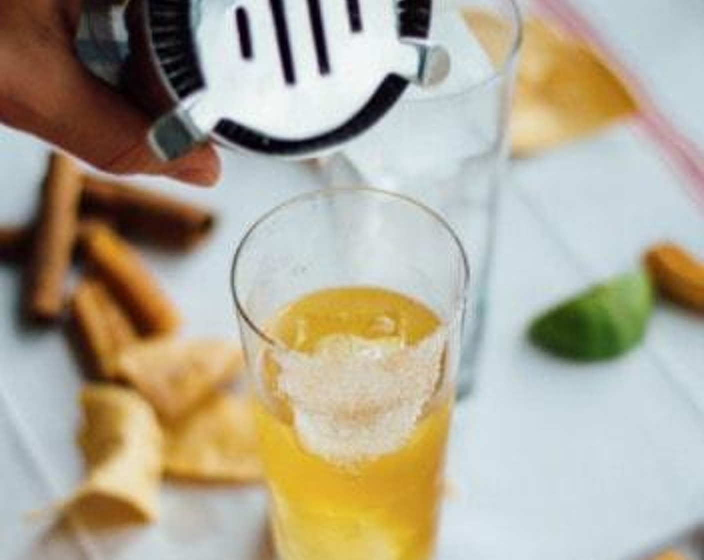 step 2 Use a lime wedge to coat the edge of your glass, and dip in Cinnamon Sugar (2 Tbsp). Pour margarita over ice. Add Ground Cinnamon (1 dash).