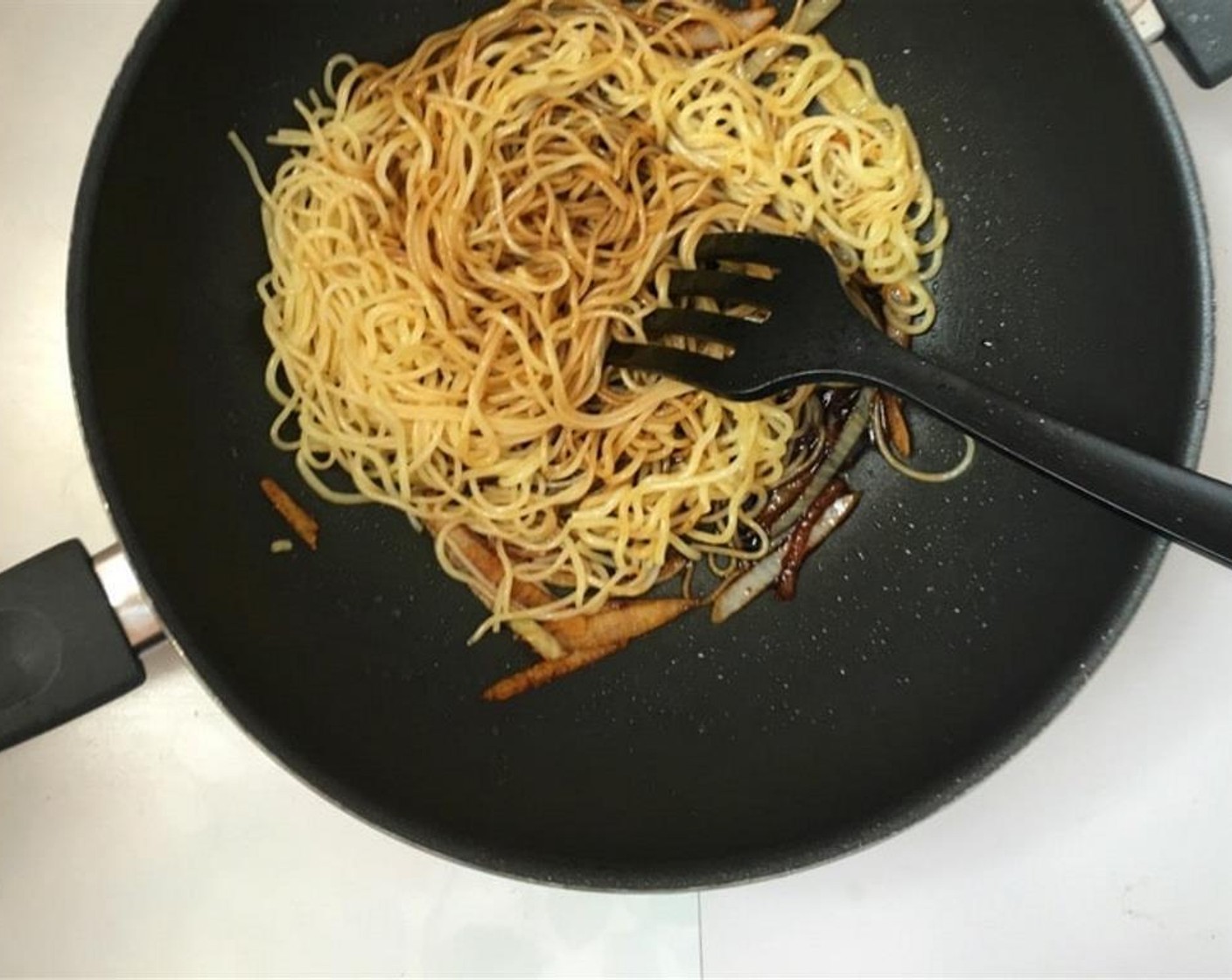 step 4 Add the noodles back to the wok and drizzle with the soy sauce mixture.