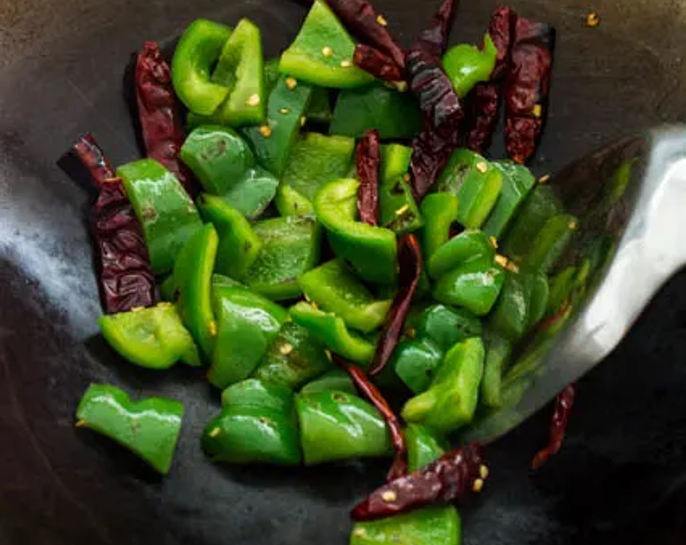 step 3 Heat Cooking Oil (2 Tbsp) in a wok over medium-high heat. Add Green Bell Pepper (1) and Dried Red Chili Peppers (6). Stir-fry slowly, allowing the skin of the bell pepper to blister, then remove the peppers and dried chili from the wok.