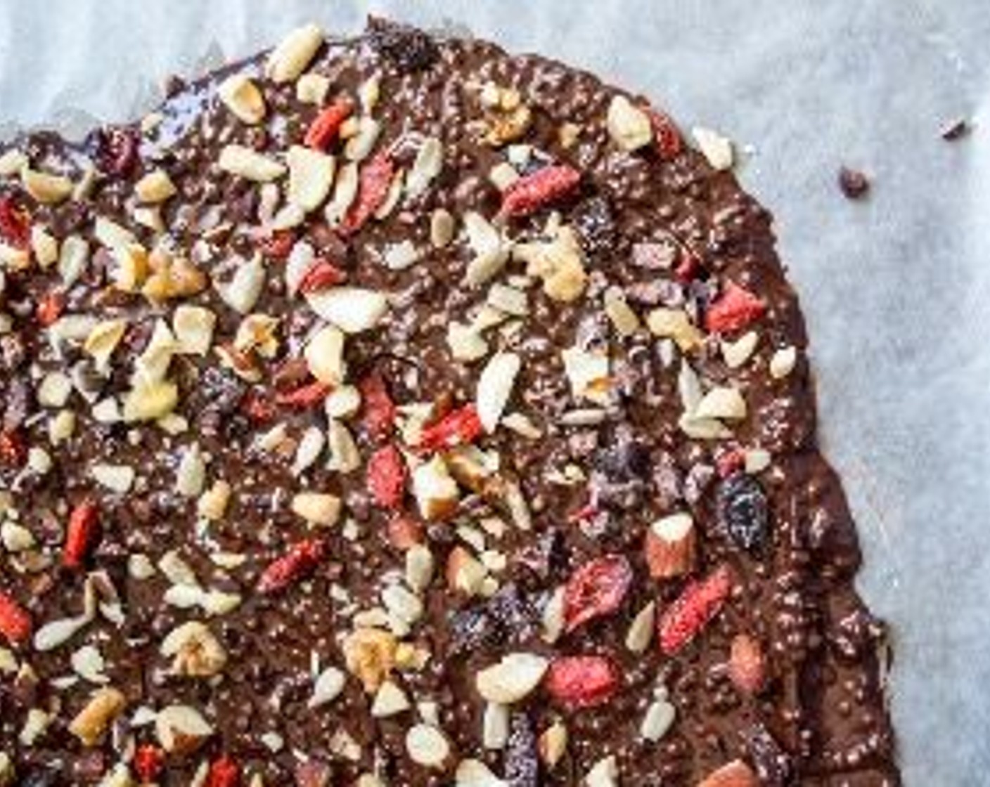 step 8 Add Goji Berry Trail Mix (1/3 cup), Cacao Nibs (2 Tbsp), and Walnut (1/4 cup), then press down lightly to mix toppings into chocolate. Put in freezer for 15-20 minutes, or until chocolate has hardened.