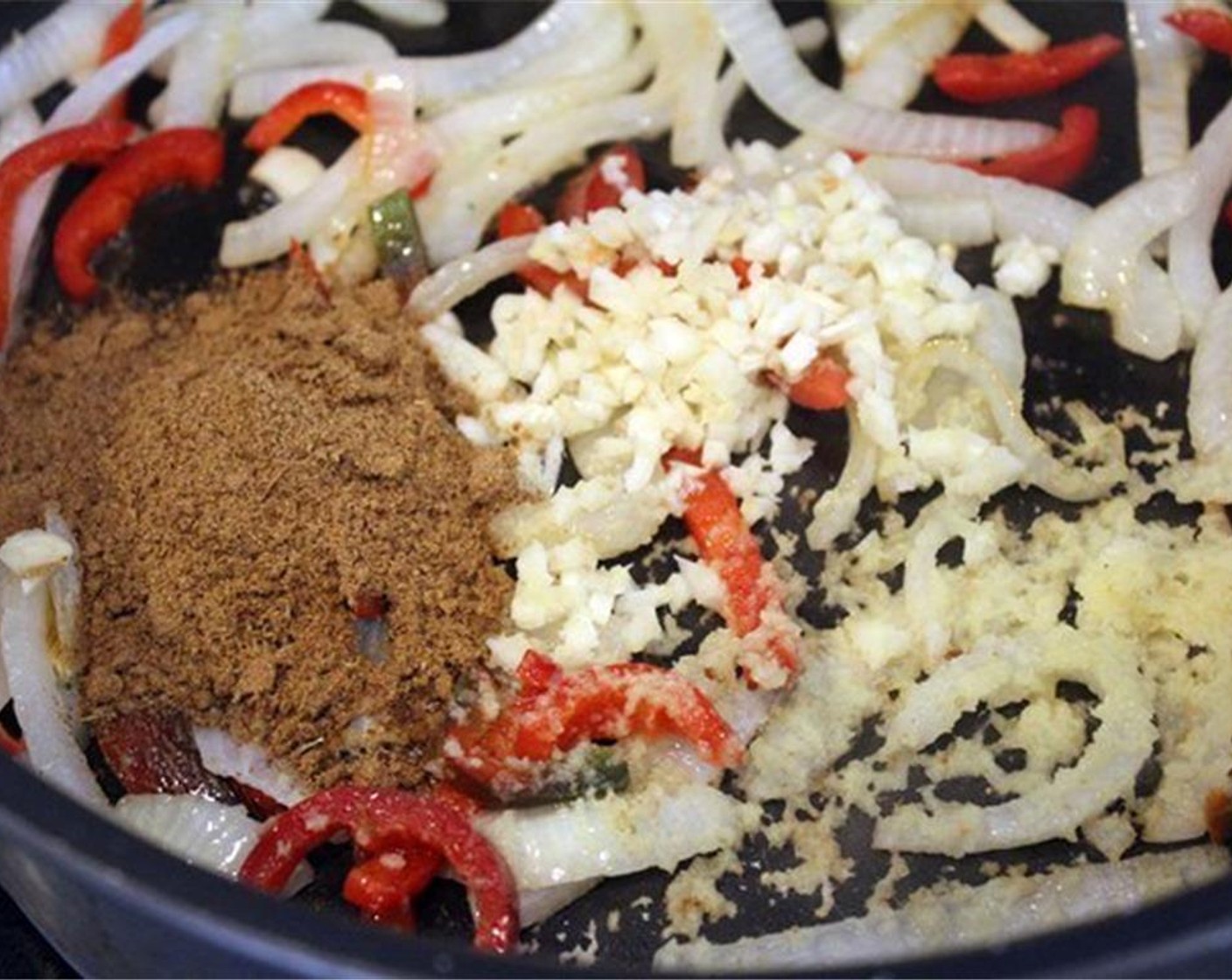 step 17 Add the Garam Masala (2 Tbsp), garlic, and ginger to the pan and let cook for one minute or until fragrant.