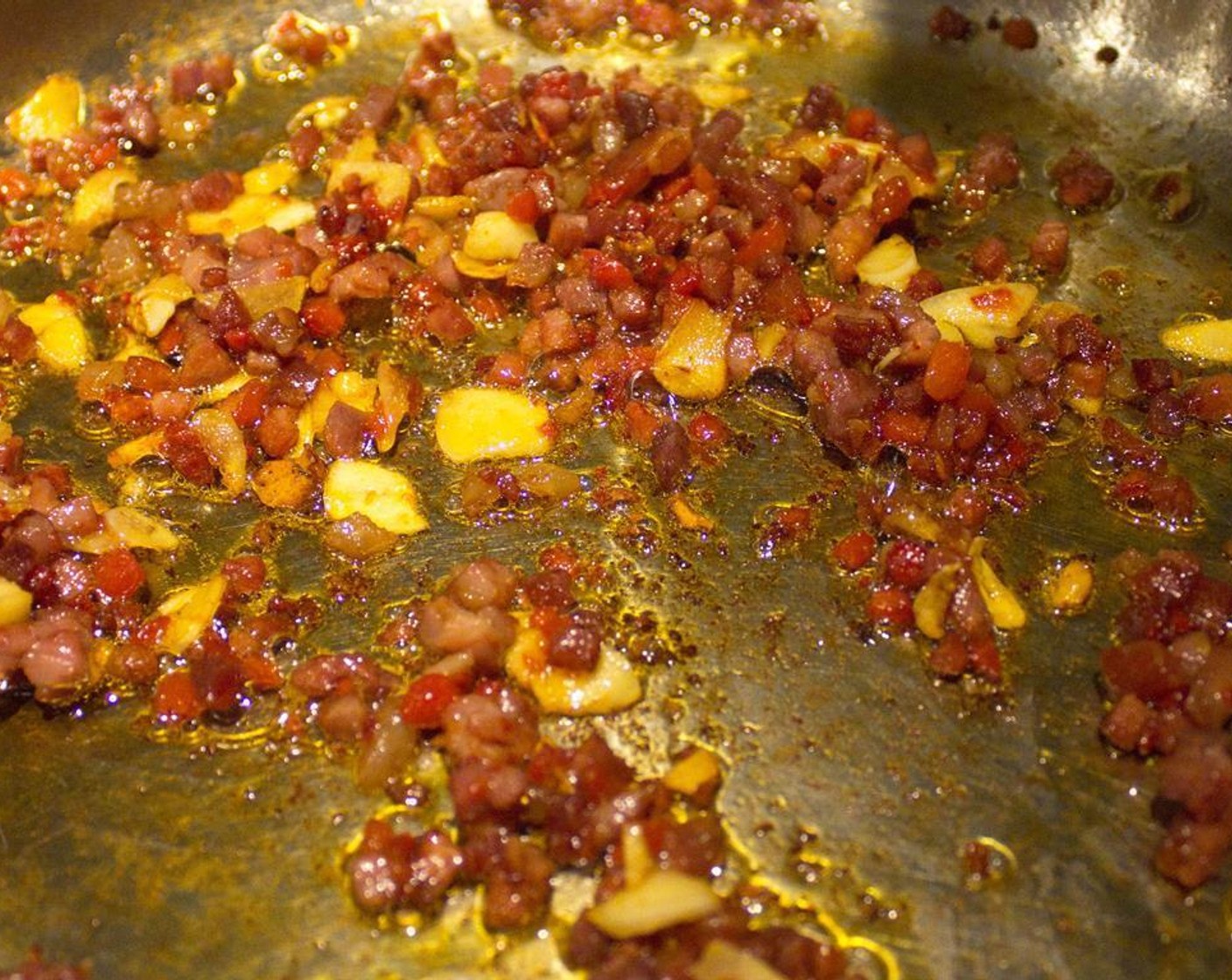 step 3 While that's cooking, heat a large skillet to medium-high with Olive Oil (as needed) to coat. Add the Pancetta (1/2 cup)  and cook until just starting to crisp. Add the pimientos and garlic and cook for 1-2 minutes.