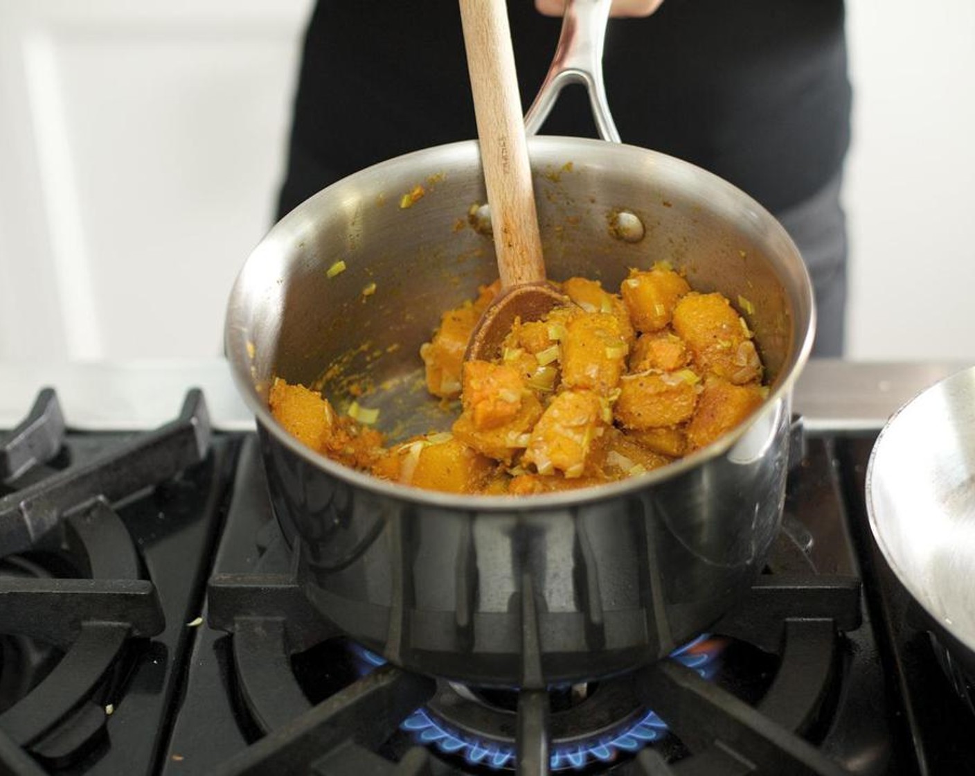 step 2 Heat the Coconut Oil (2 Tbsp) in a medium saucepan over medium-high heat. When the oil is hot, add the cubed Butternut Squash (4 3/4 cups) and cook for five minutes.