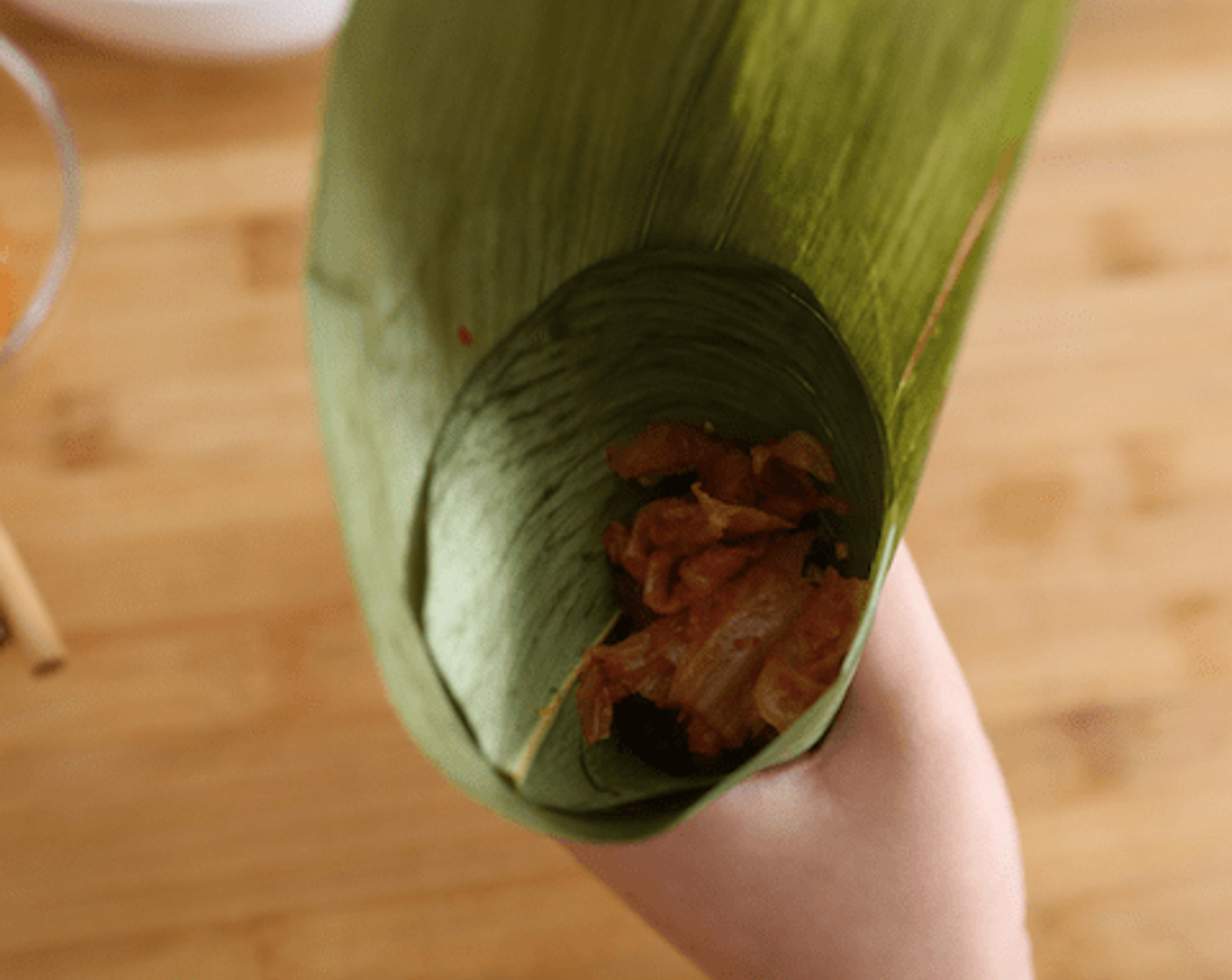 step 8 First, wrap each palm leaf into a cone safe and add in the Glutinous Rice (1 3/4 cups).