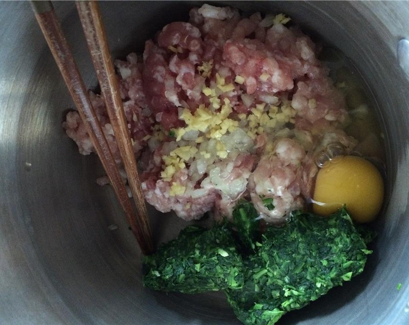 step 5 In a bowl, add the Ground Pork (9 oz), minced ginger, scallion, Egg (1), shepherd's purse, Salt (1 Tbsp), and Chicken Bouillon Powder (1 Tbsp).  Mix everything until combined.