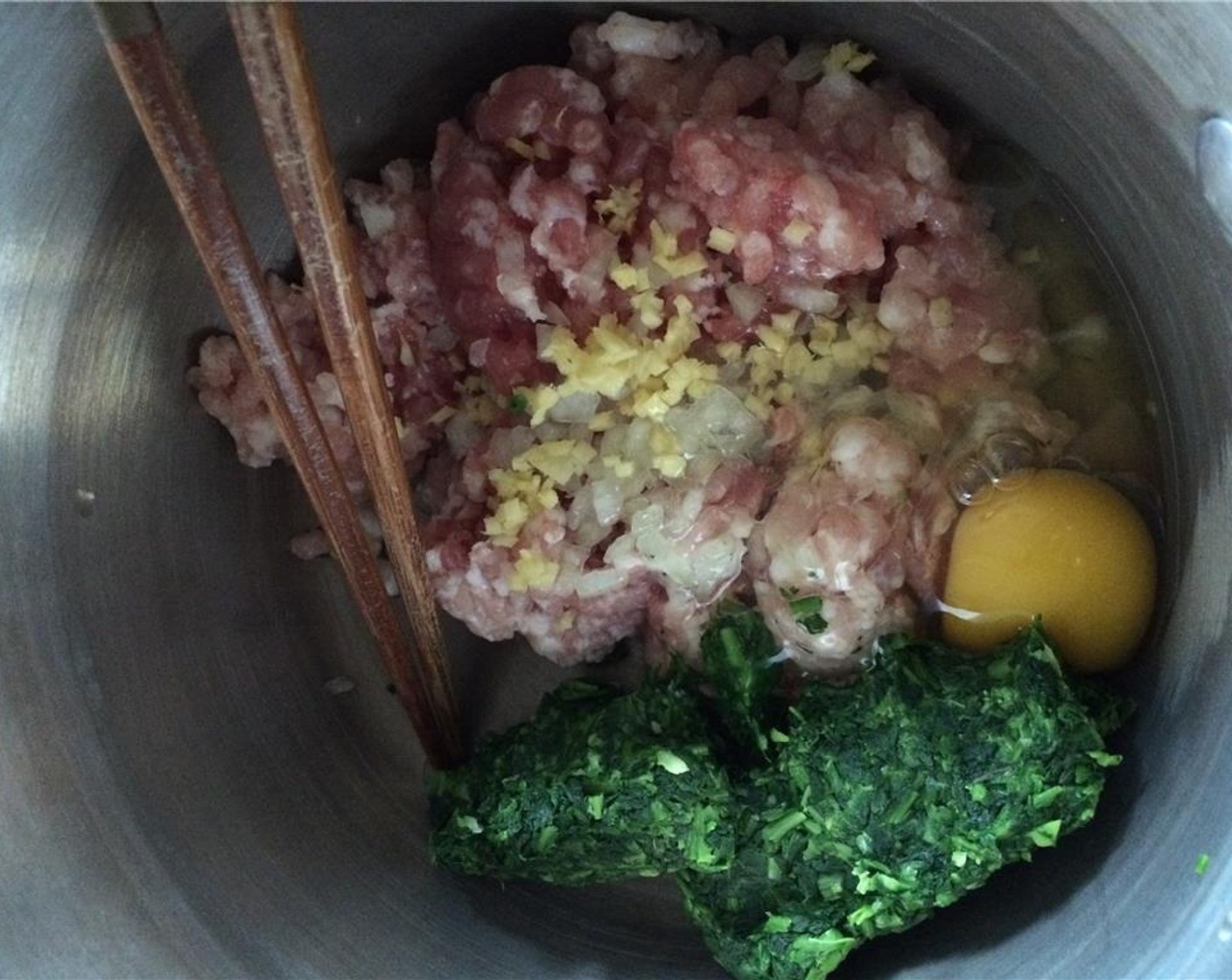 step 5 In a bowl, add the Ground Pork (9 oz), minced ginger, scallion, Eggland's Best Classic Egg (1), shepherd's purse, Salt (1 Tbsp), and Chicken Bouillon Powder (1 Tbsp).  Mix everything until combined.