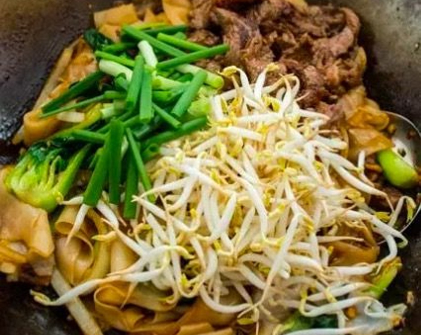 step 8 Return the beef to the wok, then add the Bean Sprouts (1 1/2 cups) and Scallions (3 stalks). Mix to combine.