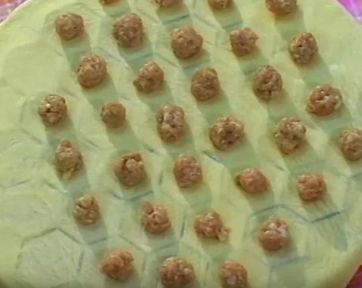 step 5 Make a small pieces of round meat balls from the grinded meat. Put the flattened dough on a dumpling cutter, and place the small meat balls on top.