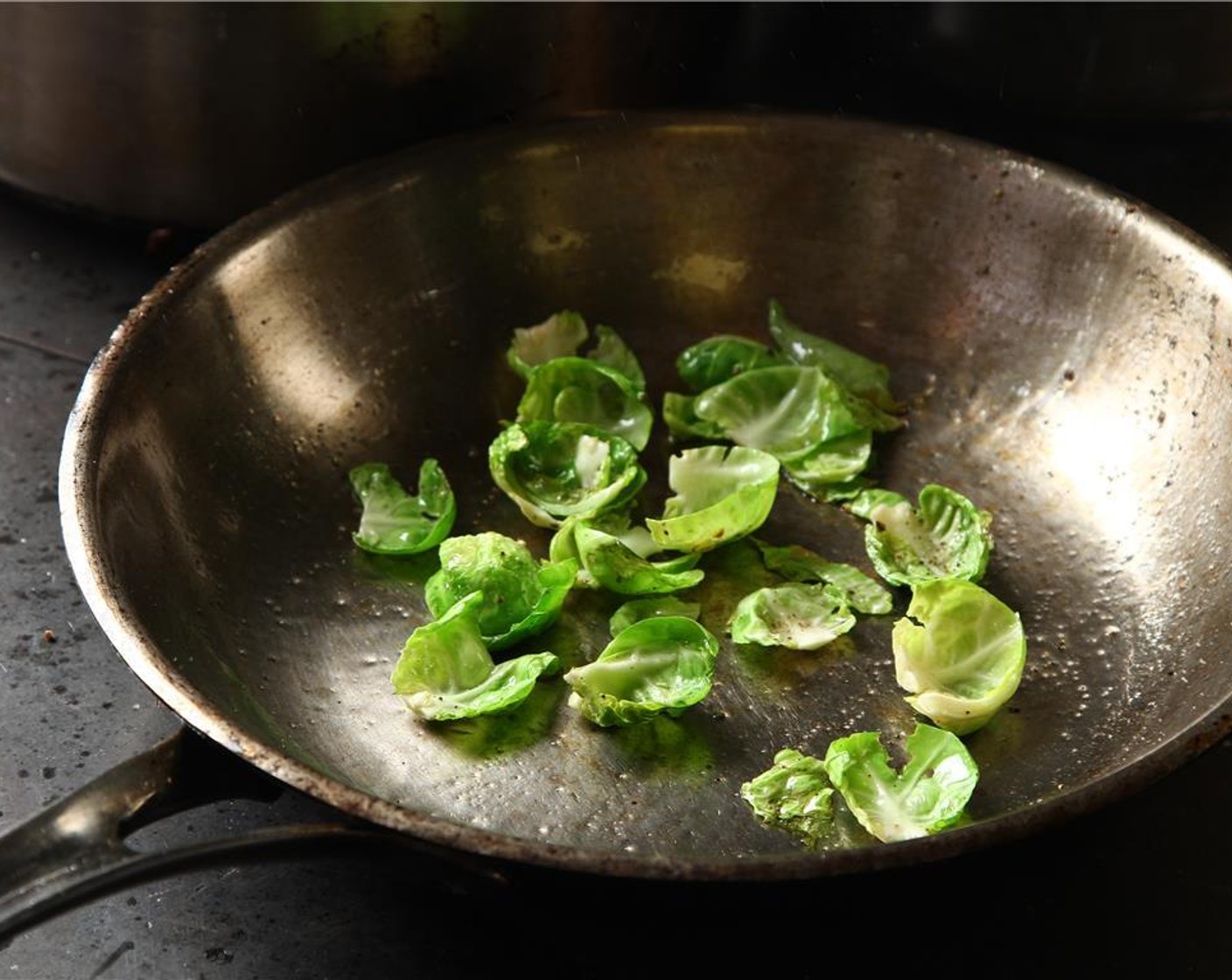 step 27 To cook leaves simply heat a new pan over medium-high heat.  oil should almost be smoking when you add to the pan.  Then, very quickly, add the sprout leaves, season with salt and pepper, and toss about.