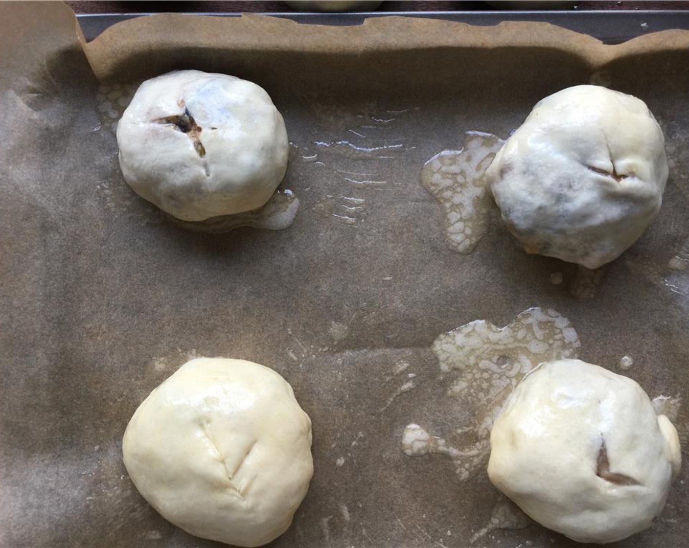 step 20 Place the buns on a parchment lined sheet pan with 2-inches between them. With a knife, lightly make an "x" on the top of the bun. Brush them with the sage butter, and place them in the oven for 15 minutes, or until golden. Rotate pan(s) halfway through.