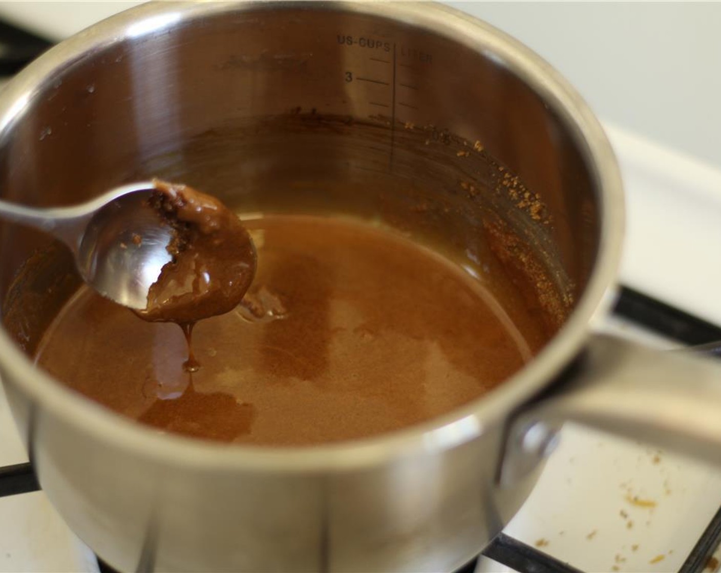 step 2 Pour the Raw Cane Sugar (1 cup) into a small saucepan. Heat it over medium heat, and stir the sugar until it starts to melt. Turn the heat down to medium-low and continue stirring until it has melted completely.