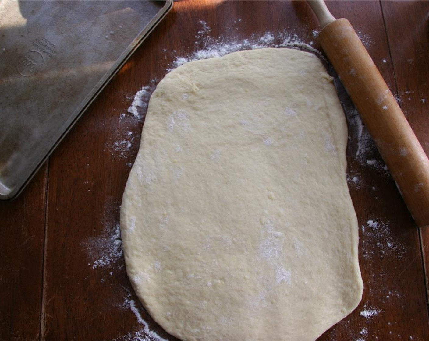 step 7 Grease the bottom and sides of a 9×12-inch baking sheet or jelly roll pan. Return the dough to a work surface and roll or push it out into a rectangle the size of the pan. Place the dough in the pan and push it down to fill the pan. Cover and let rise for 45 minutes.