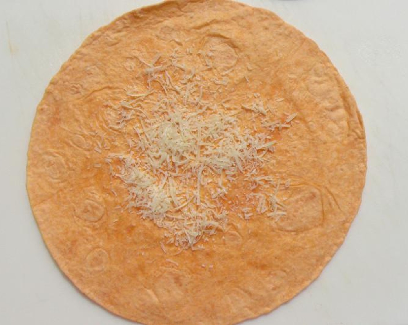 step 1 Sprinkle Grated Parmesan Cheese (1 pinch) in the center of the Tortilla (1).