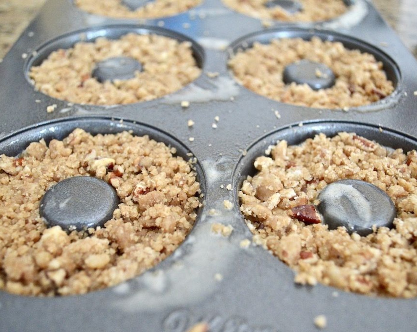 step 7 Take out the topping mixture and crumble it up. Sprinkle a thick layer on top of each donut and press the crumbs firmly into the donut batter so that it all holds together.