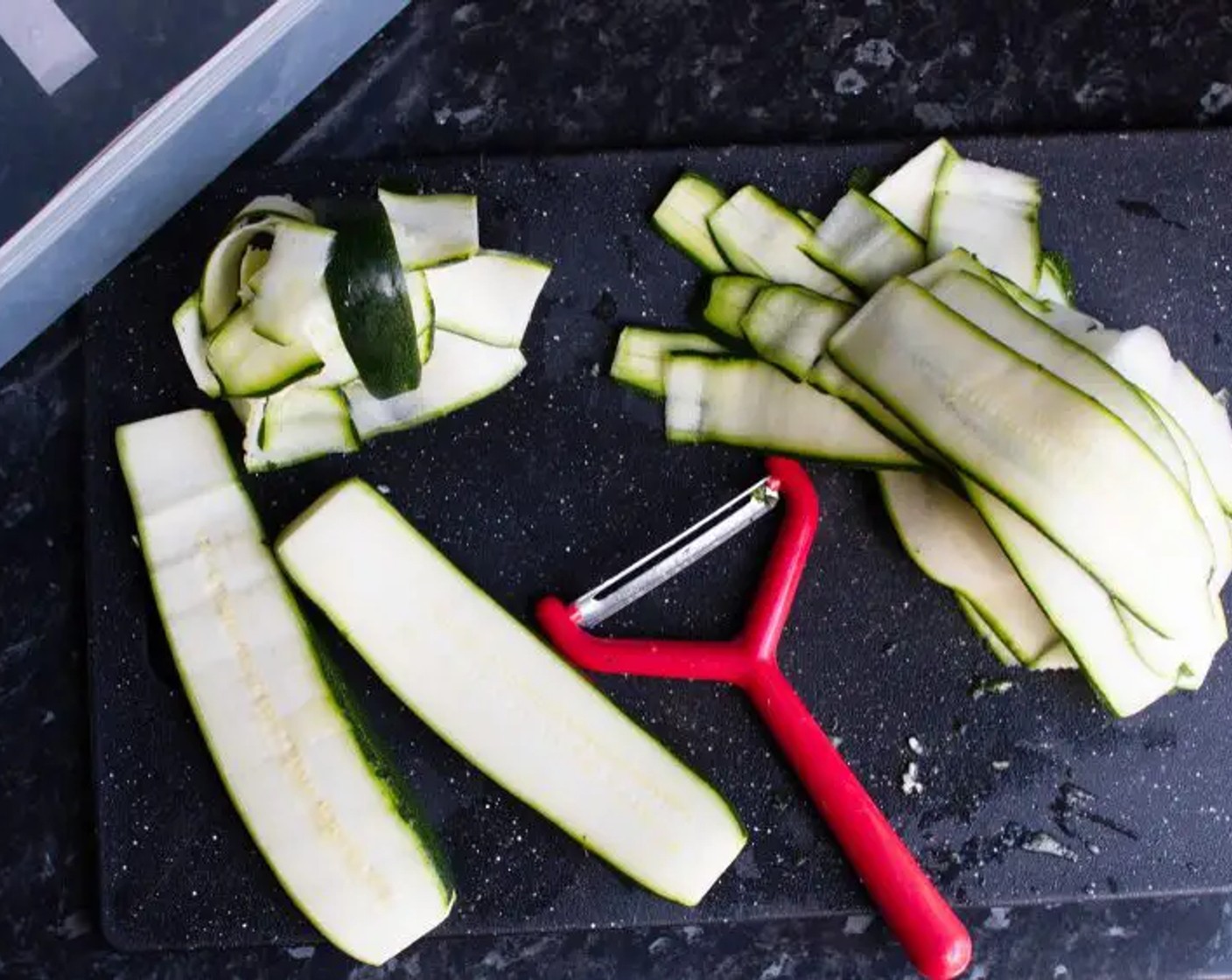 step 1 Using either a peeler or cheese slicer, peel along the Zucchini (2) lengthways to get long, thick “ribbons”.