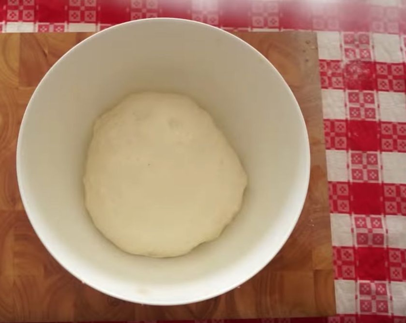 step 4 Prepare a mixing bowl by drizzling some Extra-Virgin Olive Oil (as needed) in it and basting it around the sides, then place the ball of pizza dough inside. Using your hands, knead the dough inside the bowl, covering it with the oil and forming a round ball.