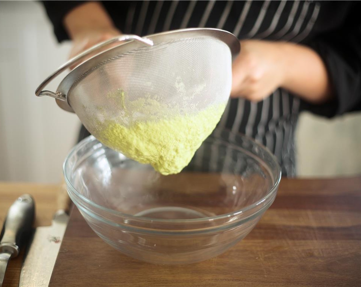 step 12 Meanwhile, mash the avocado together with the lime juice, Sour Cream (2 Tbsp), and Salt (1/4 tsp) by using the back of a spoon. Transfer the mixture to a strainer, and use the back of a spoon to push the mixture through and back into the bowl.