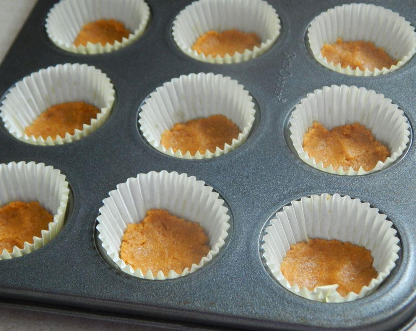 step 2 In a small bowl, mix your Graham Cracker Crumbs (1/2 cup) and Vegetable Oil Spread (1 1/2 Tbsp) together. Fill your 18 muffin cups with the crumb mixture, and pat down with your fingers.