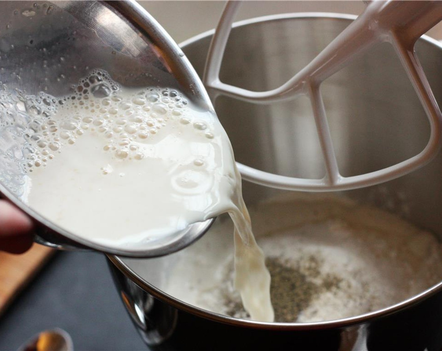 step 2 In a separate bowl, whisk together the Instant Dry Yeast (1/2 Tbsp) and Milk (1 cup) until yeast is dissolved. Add the yeast mixture and Butter (1/4 cup) to the mixer bowl and mix with a wooden spoon until loosely combined.