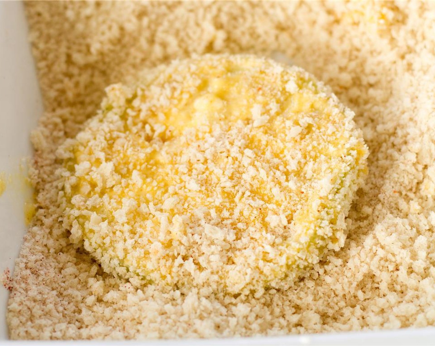 step 6 Once you've got your bowls of ingredients set up, dunk each tomato slice first in the flour mixture, then in to the eggs wash, and finally into the bread crumb mixture. Then set each slice aside on a plate or tray until all the tomatoes are used up.