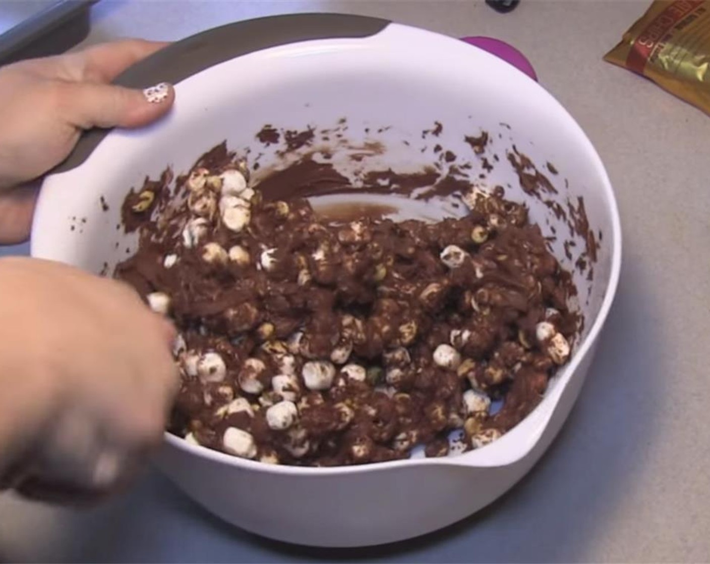 step 3 Remove from microwave, and stir until chocolate is completely melted. Let cool 5 minutes, then stir into the marshmallow peanut mixture until completely coated.