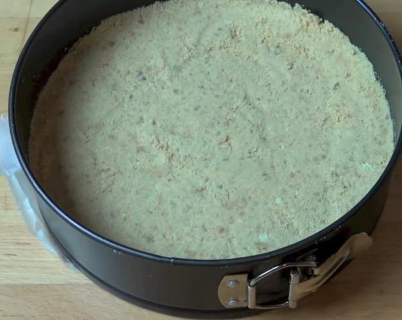 step 2 Transfer the mixture into a 22-centimeter springform tin. Use the base of a flat-bottomed glass to  press down the cookie mixture. Place in fridge to chill.