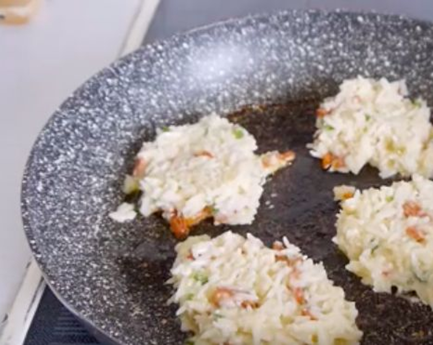 step 3 In a pan oiled with Vegetable Oil (1 1/3 Tbsp), place 1 to 1 1/2 spoon full of the mix and pat gently to form the rice cake.