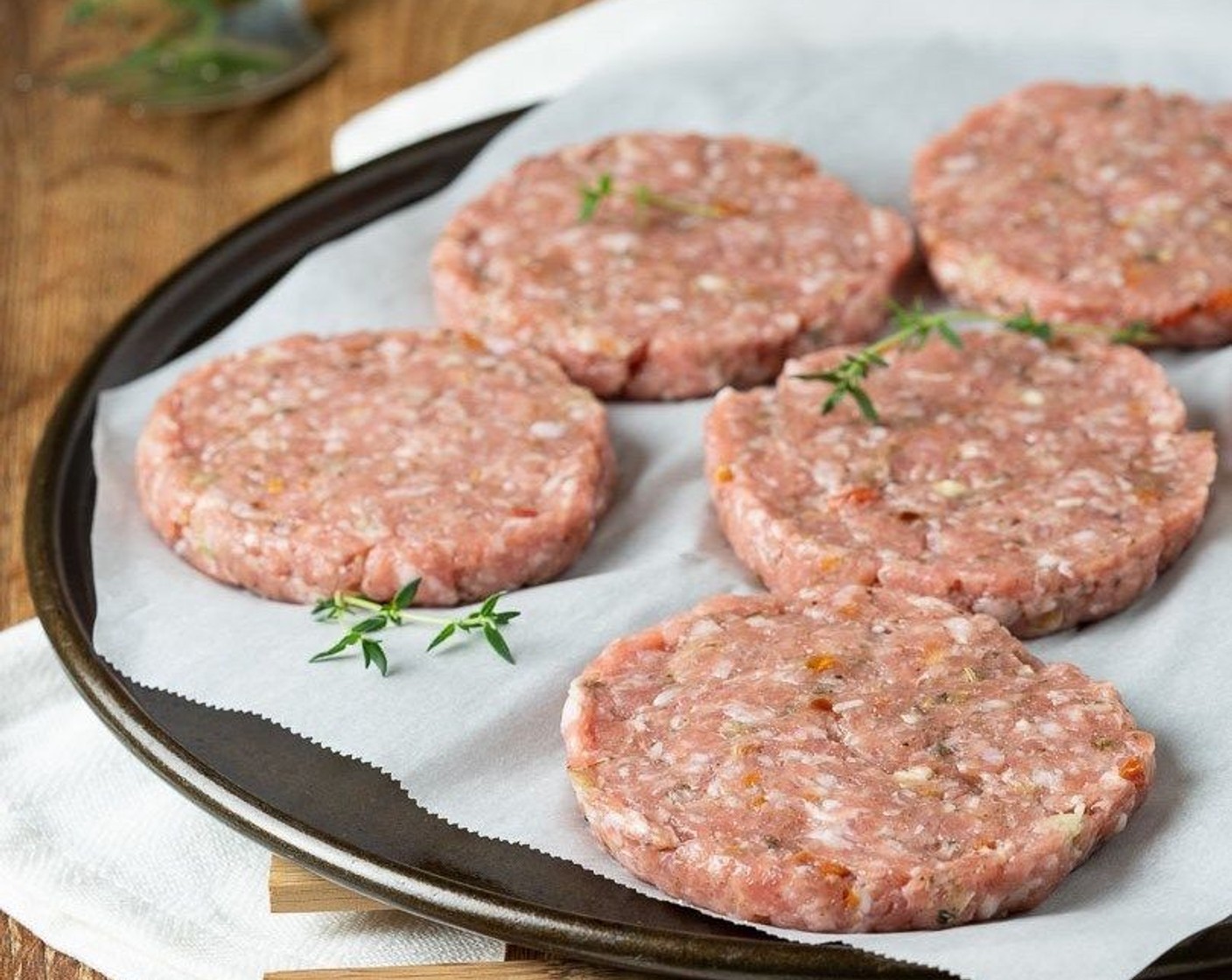 step 4 Portion mixture into 2.5 ounces each. Form into 3 1/2-inch patties either using your hands or pressing into a ring mold. Place on a flat plate or tray and separate layers with parchment.