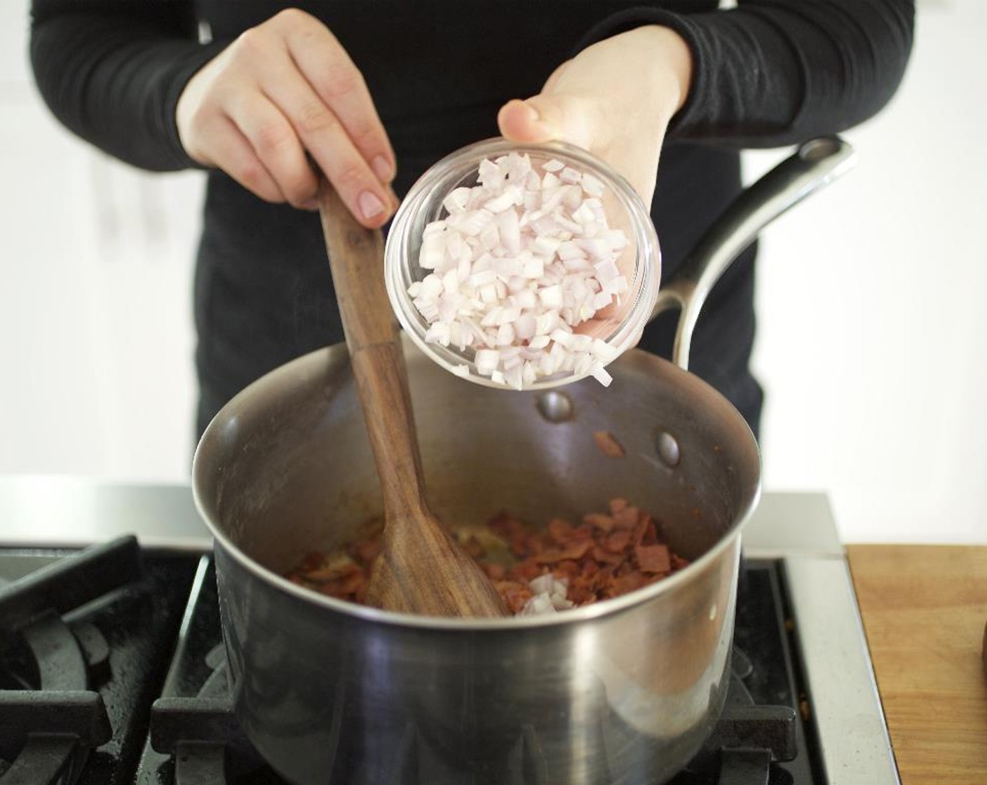 step 10 While the pasta is cooking, add the shallot, garlic and red bell pepper mixture to the chorizo and ham; reduce the heat to medium. Sauté for 5 to 7 minutes.