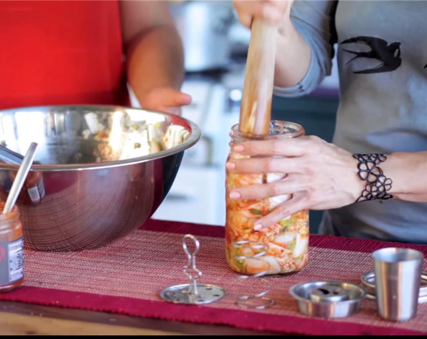 step 6 Using a mortar, or wooden spoon, pound down the mixture to help release more liquid. Be firm here and really pack down the cabbage mixture until it is level with the shoulder of the jar.