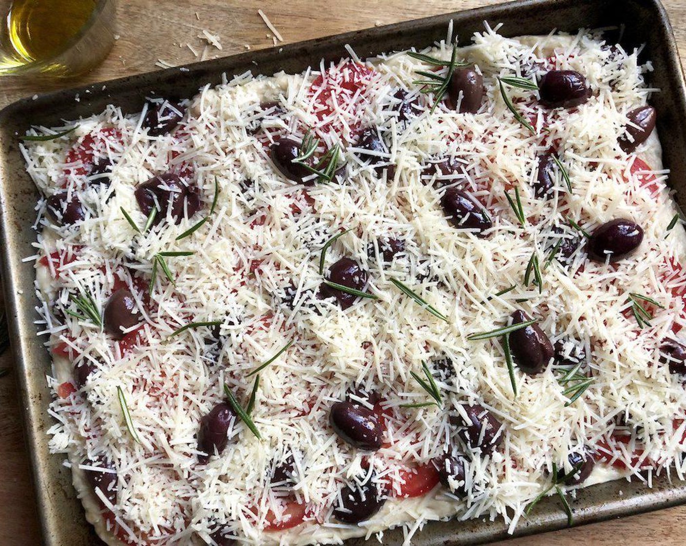 step 6 Finish off by sprinkling with the remaining Asiago Cheese (2/3 cup) and Rosemary Leaves (1/2 Tbsp).  Allow the focaccia to rest for about 20 minutes.