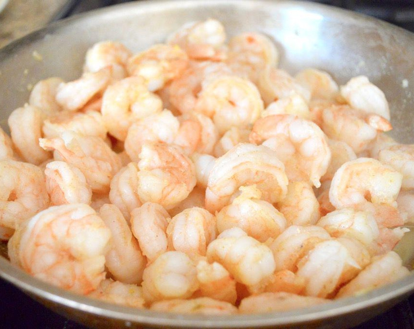step 2 Then add the Large Shrimp (2 lb) and cook it until it is pink and opaque, for about 5 minutes. While it cooks, flavor it with the Salt (1 pinch), Simply Organic Garlic Powder (1/2 tsp), Dried Onions (1/2 tsp), and Ground Cumin (1/4 tsp). Once it is cooked through, set it aside to cool.