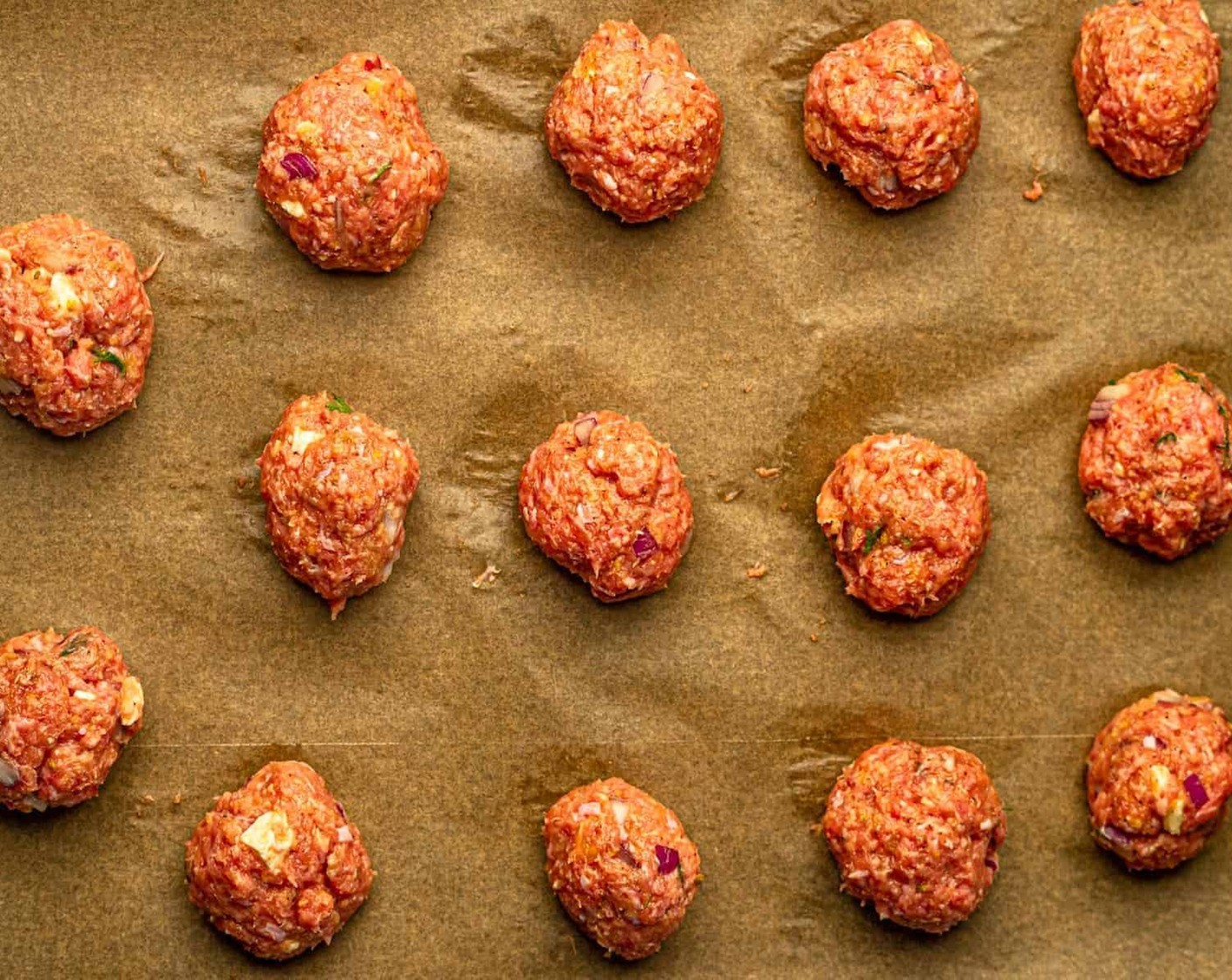 step 3 Use a cookie or ice cream scoop to form the meatballs and then roll them in between the palm of your hands. Place the meatballs on the parchment paper-lined baking sheet.
