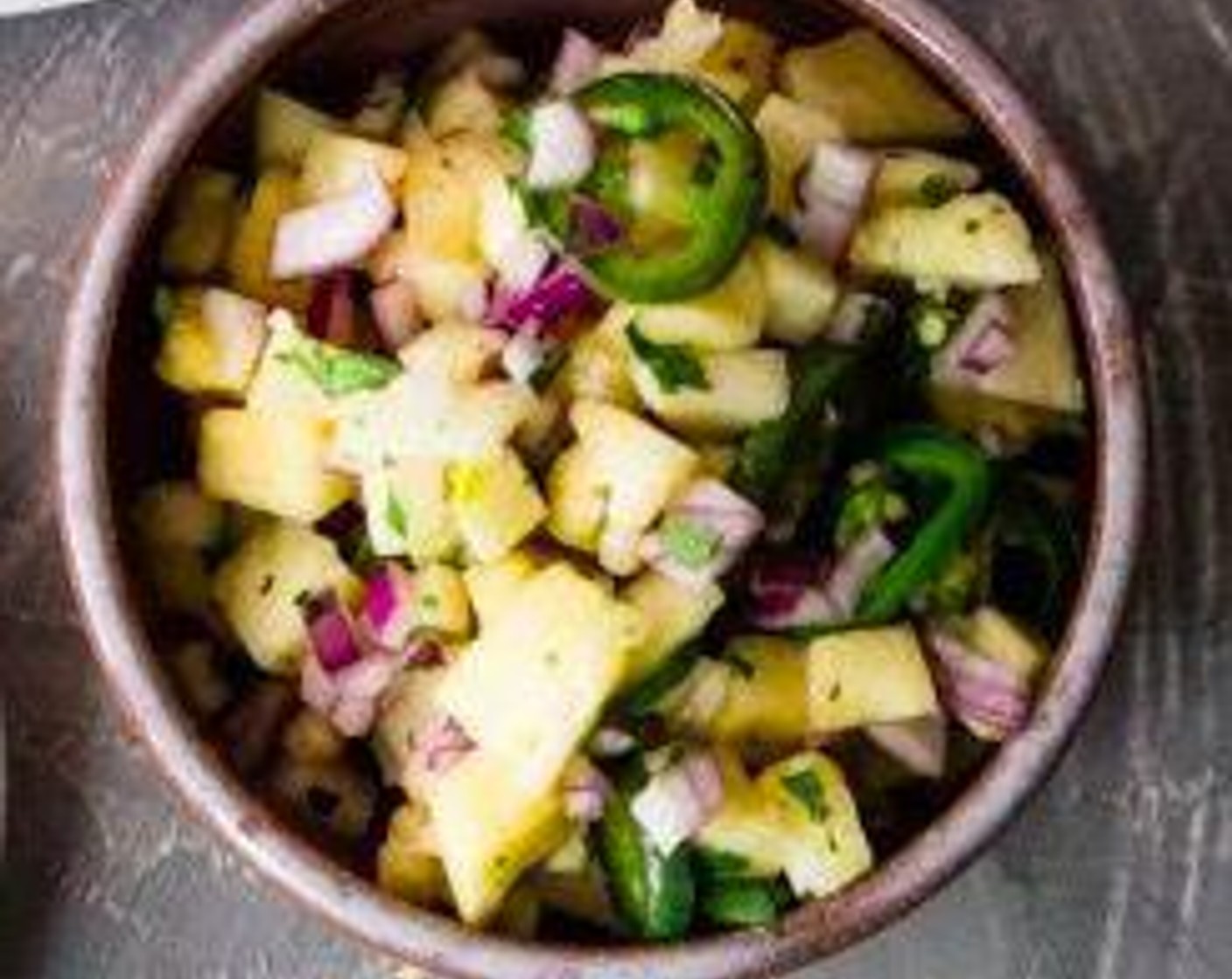 step 6 Add jalapeños to Pineapples (2 cups), Red Onion (1/2 cup), Fresh Cilantro (1/4 cup), Garlic (1 clove), and juice of half the lime. Toss together.