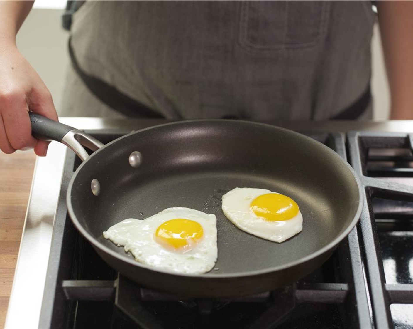 step 8 In a medium non stick pan, heat Vegetable Oil (1 tsp) over medium low heat. Carefully crack the Eggs (2) slowly into the pan next to one another, but not touching. Do not break the yolks! Season with a pinch of salt and pepper.
