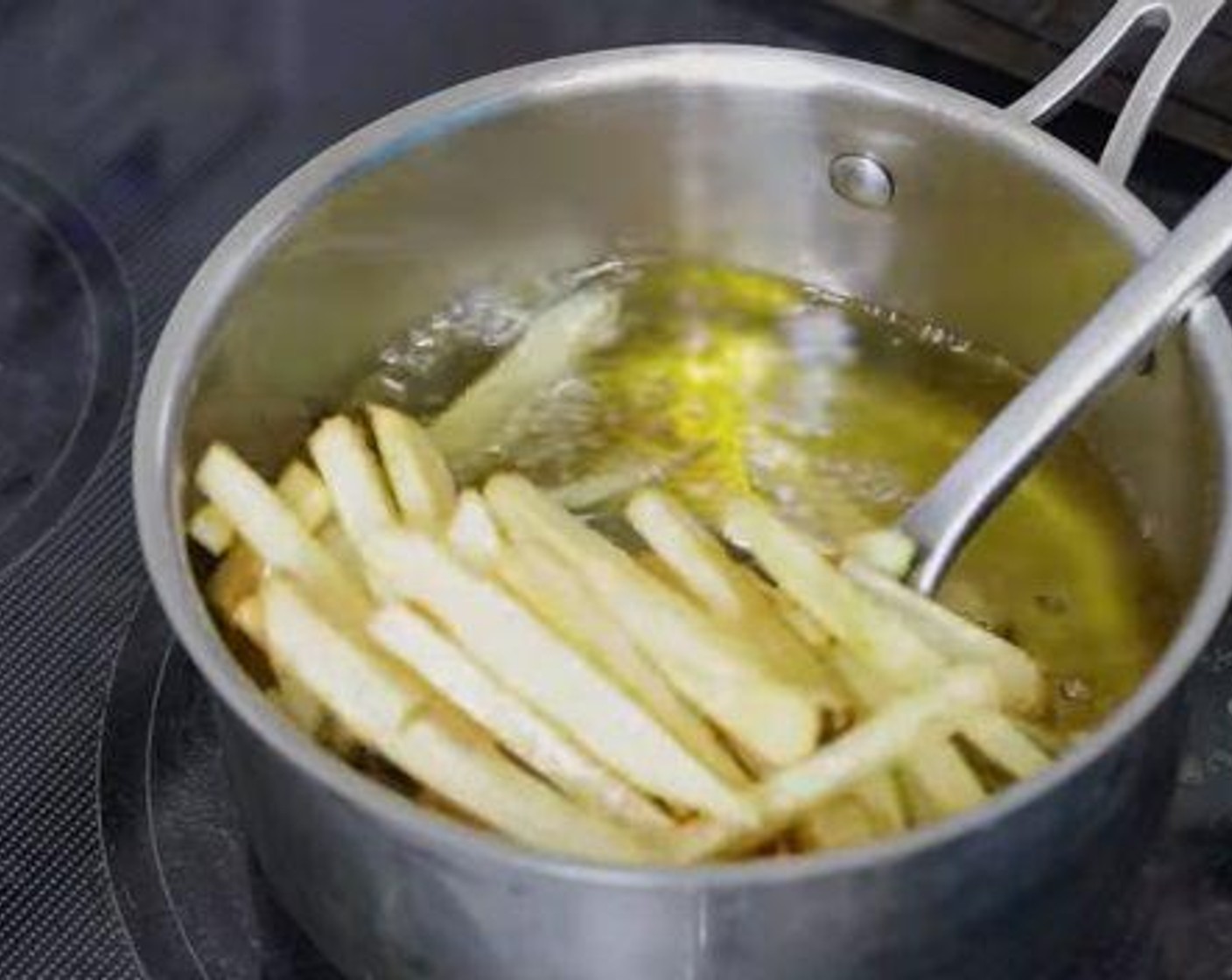 step 4 When oil reaches 320 degrees F (160 degrees C), place the potatoes in the oil. Working in small batches, fry for 2 to 3 minutes until they are floppy. Remove from oil, drain, and cool to room temperature.