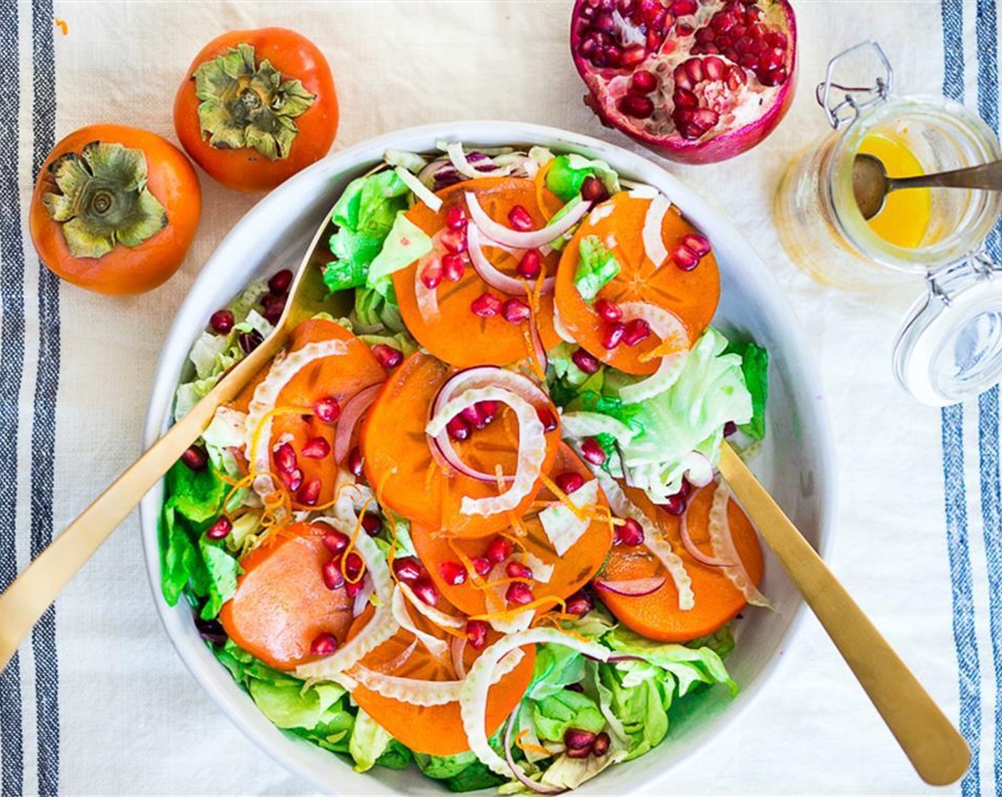 step 4 Lay a bed of dressed greens on a platter. Scatter slices of persimmon over the lettuce. Garnish with Pomegranate Seeds (1/4 cup), Pistachios (2 Tbsp), and Goat Cheese (2 Tbsp) if using. Add dressing over the top and cracked pepper.