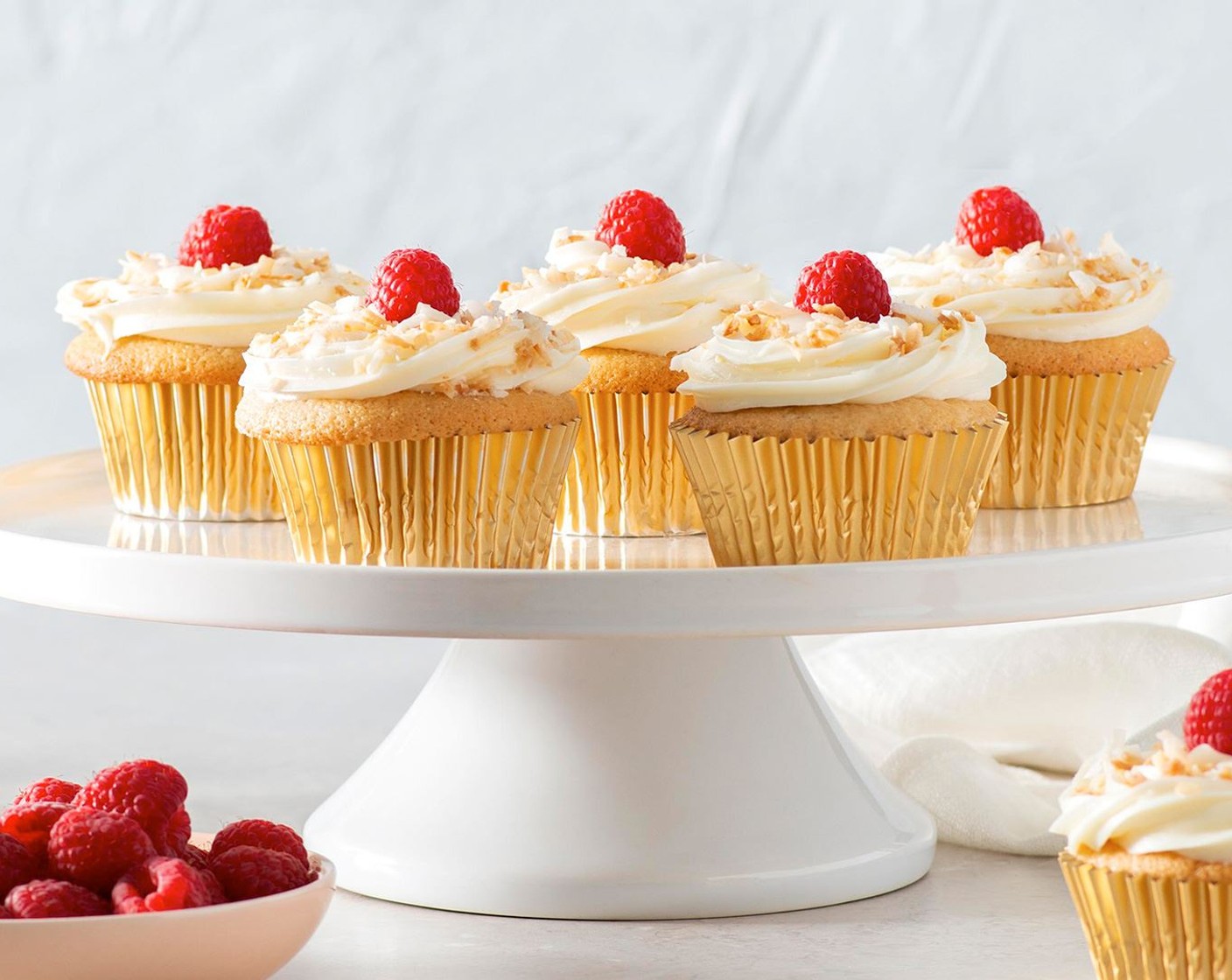 step 6 Spoon frosting into piping bag fitted with star tip; pipe icing onto each cupcake. Garnish each cupcake with sprinkle of Toasted Coconut Flakes (1 cup) and Fresh Raspberries (18) or chosen fruit garnish.